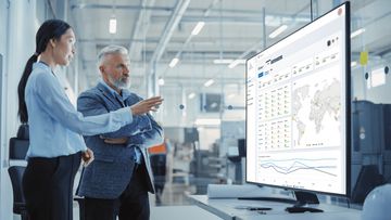 Image depicting a man and woman looking at an Arch System Dashboard.